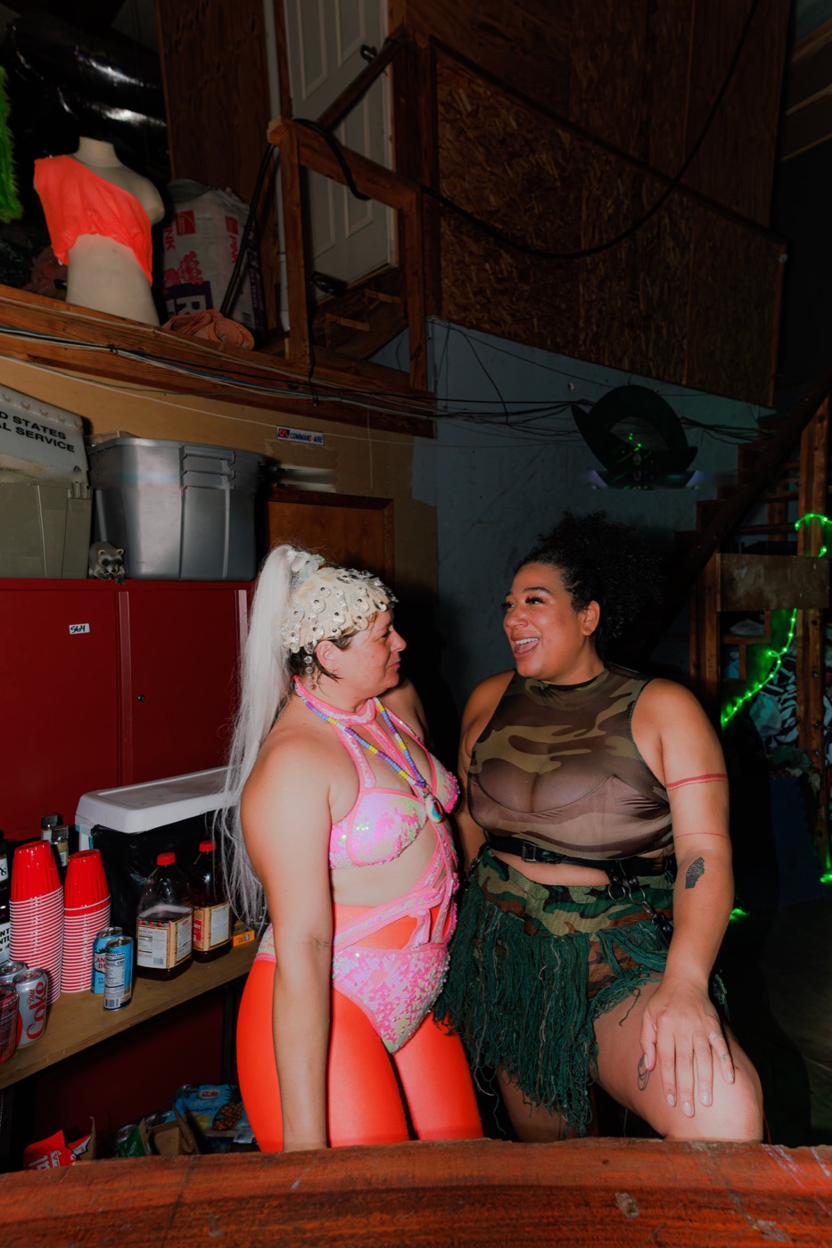 Two people laughing together by the warehouse bar at Babestock