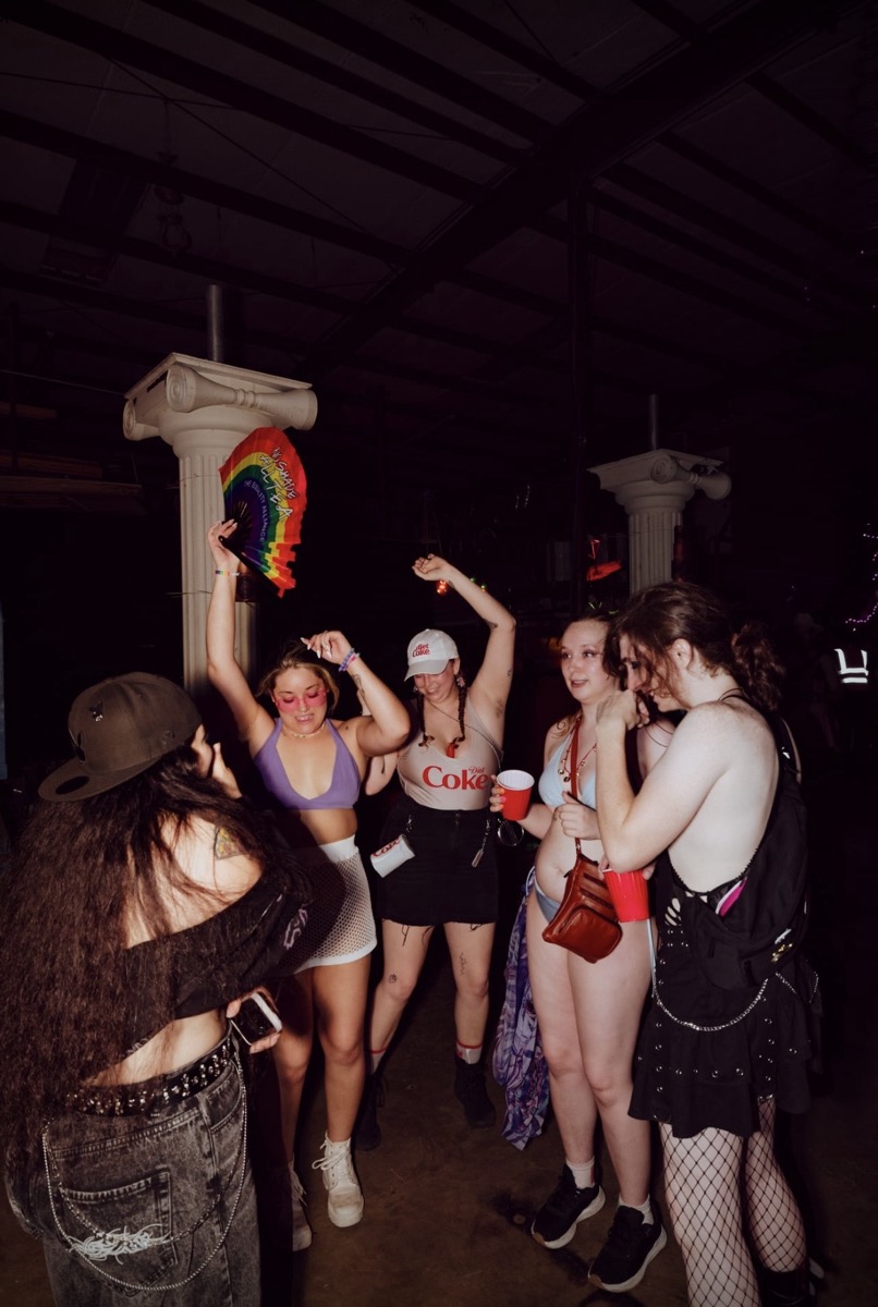 Friends dancing with a rainbow fan between the columns